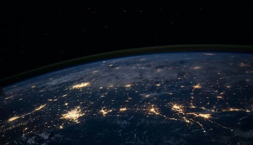 A satellite image of Earth’s horizon during night time having well-lit cities