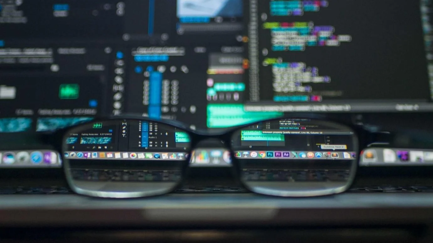  Eyeglasses resting on a laptop touchpad with a see-through image of its screen