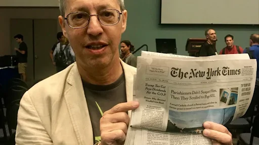 Stuart Haber displaying a copy of the New York Times with the world’s oldest running blockchain