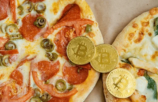 Image of golden bitcoins on top of pizza.