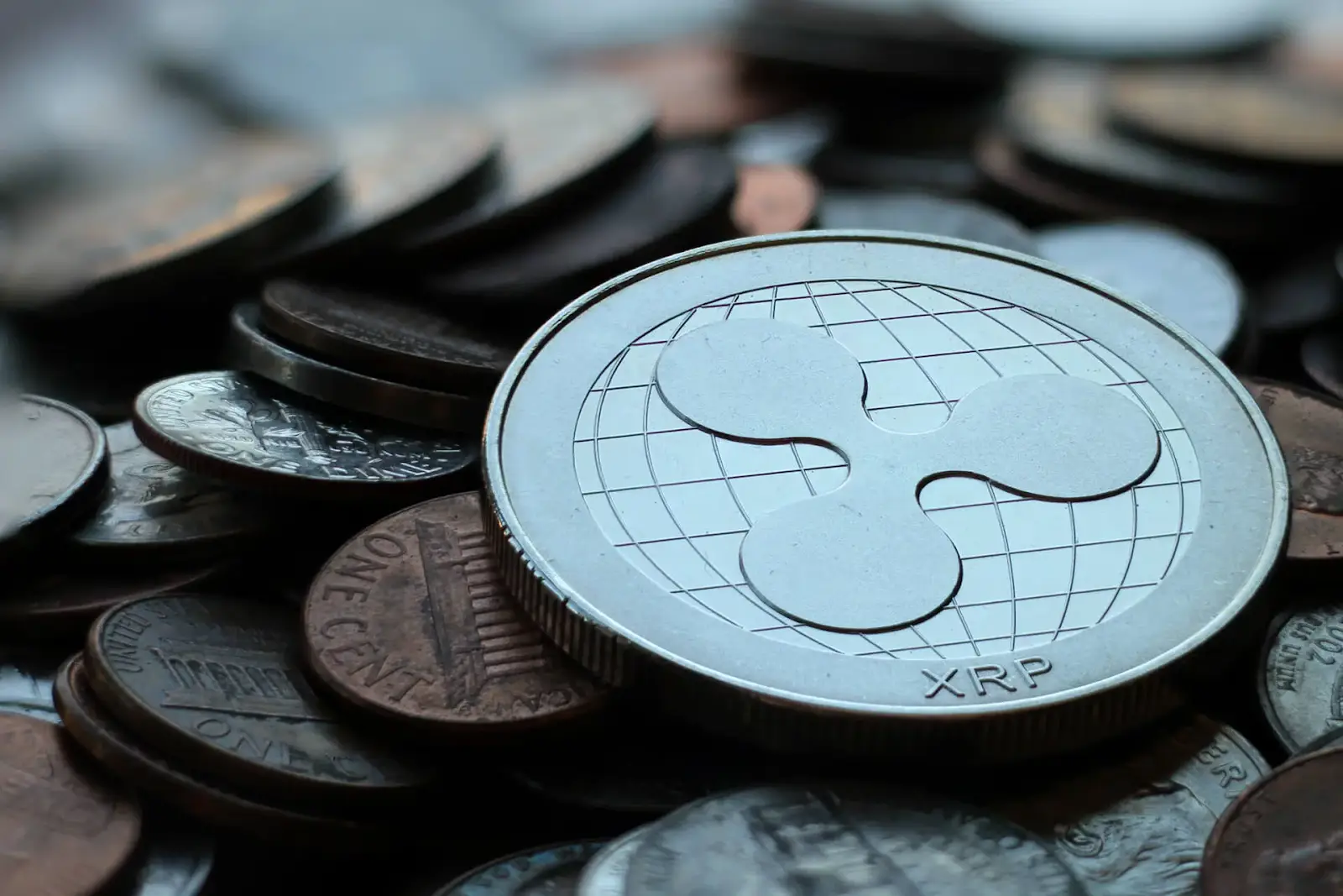 An image of an XRP coin on top of several pennies