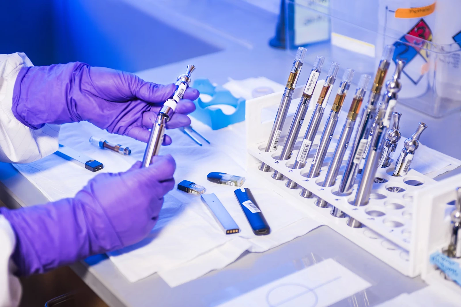 Blockchain Technology in Healthcare Gloved hands of a lab technician working with electronic cigarettes inside a lab.