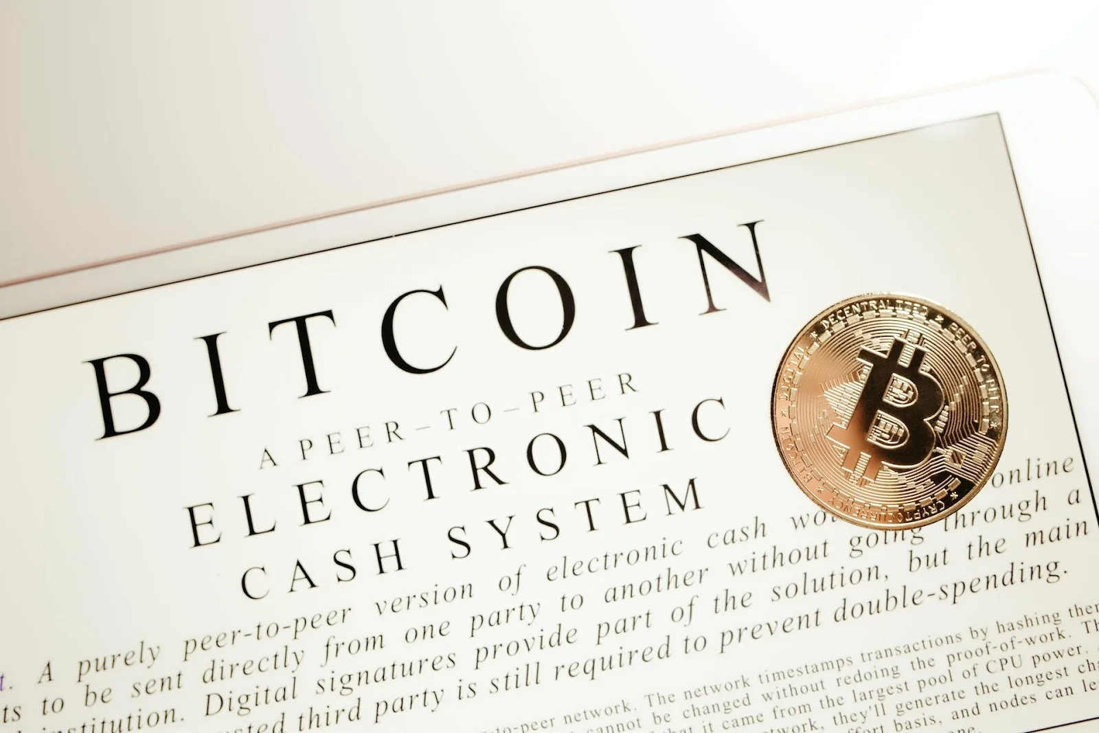 The printed Bitcoin Whitepaper with a physical Bitcoin placed over it