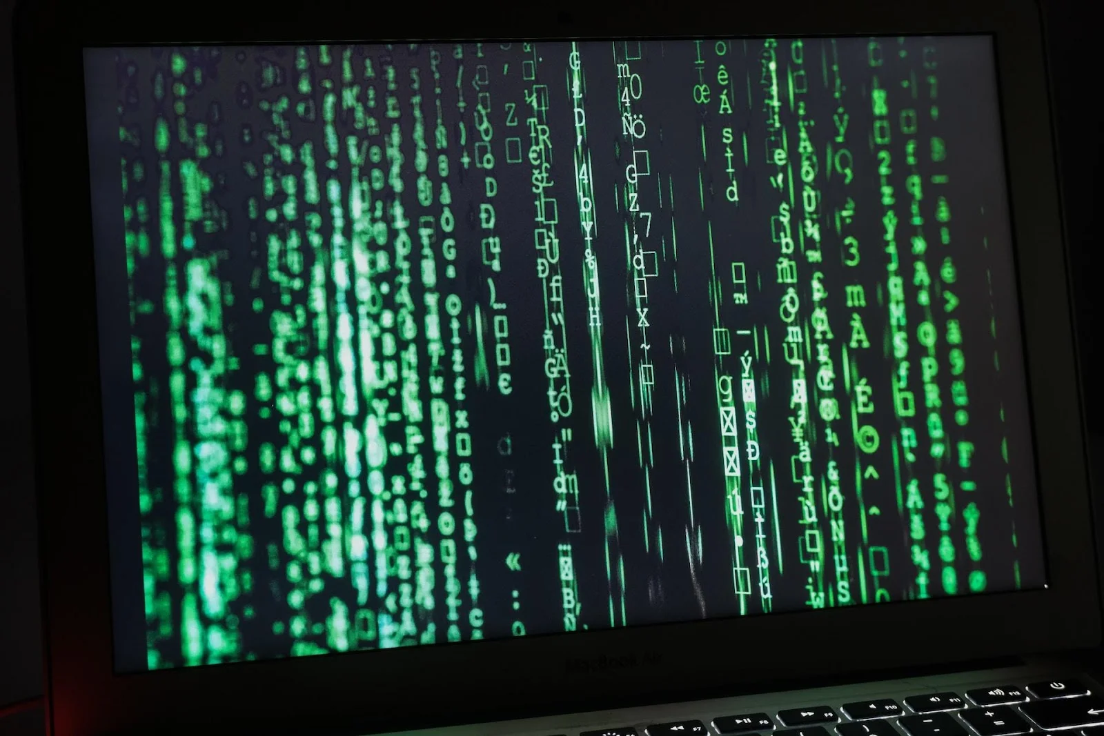 A laptop screen with a Matrix-like binary waterfall screen
